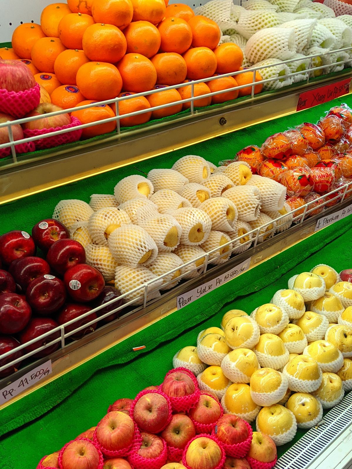 A colorful assortment of fresh apples, oranges, and more at a market stall.