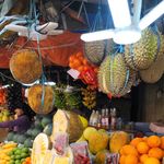 A colorful display of tropical fruits at a market stall in the Philippines, showcasing durian, oranges, and jackfruit.