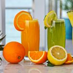A vibrant array of fresh fruit juices with garnishes, offering a healthy and refreshing drink option.