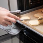 Close-up of cookies on a tray being baked in a kitchen oven.