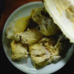 Close-up of durian fruit segments served on a white plate.