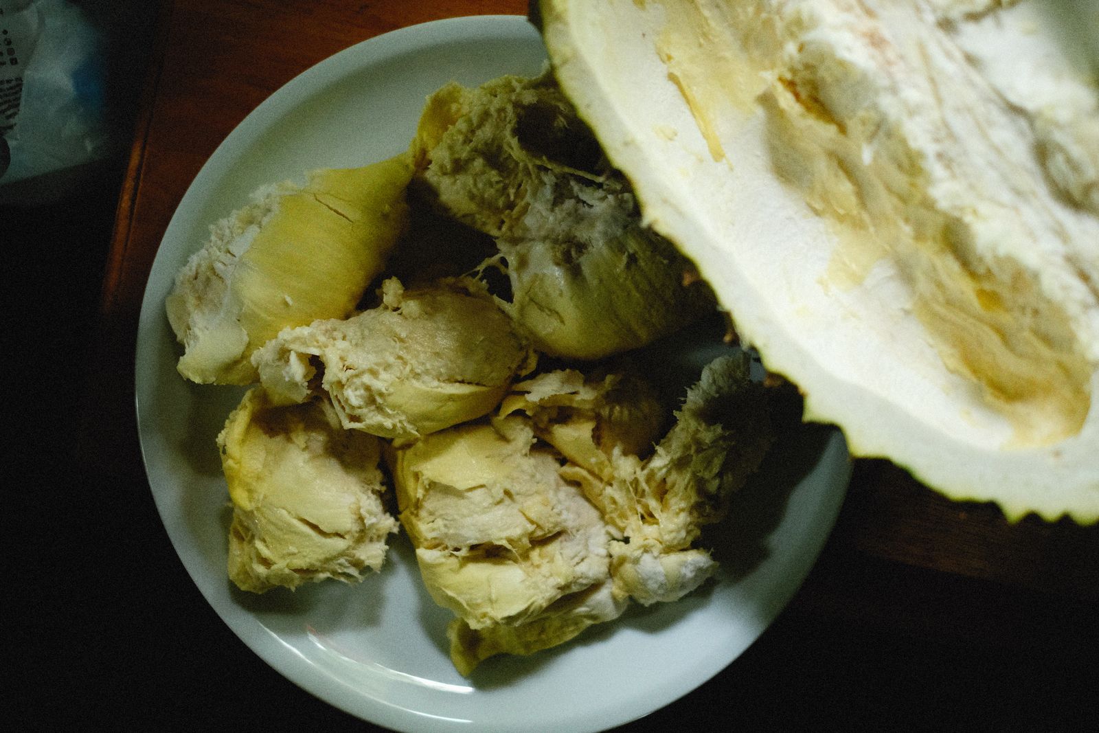 Close-up of durian fruit segments served on a white plate.