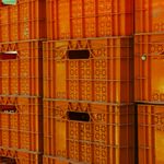 Close-up view of orange plastic crates stacked, ideal for industrial packaging concept.