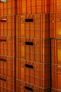 Close-up view of orange plastic crates stacked, ideal for industrial packaging concept.