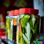 Colorful jars of pickled mangoes showcasing vibrant tropical fruit preserved in brine.