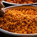Delicious roasted chickpeas in a metal bowl, showcasing vibrant orange color and healthy snack appeal.