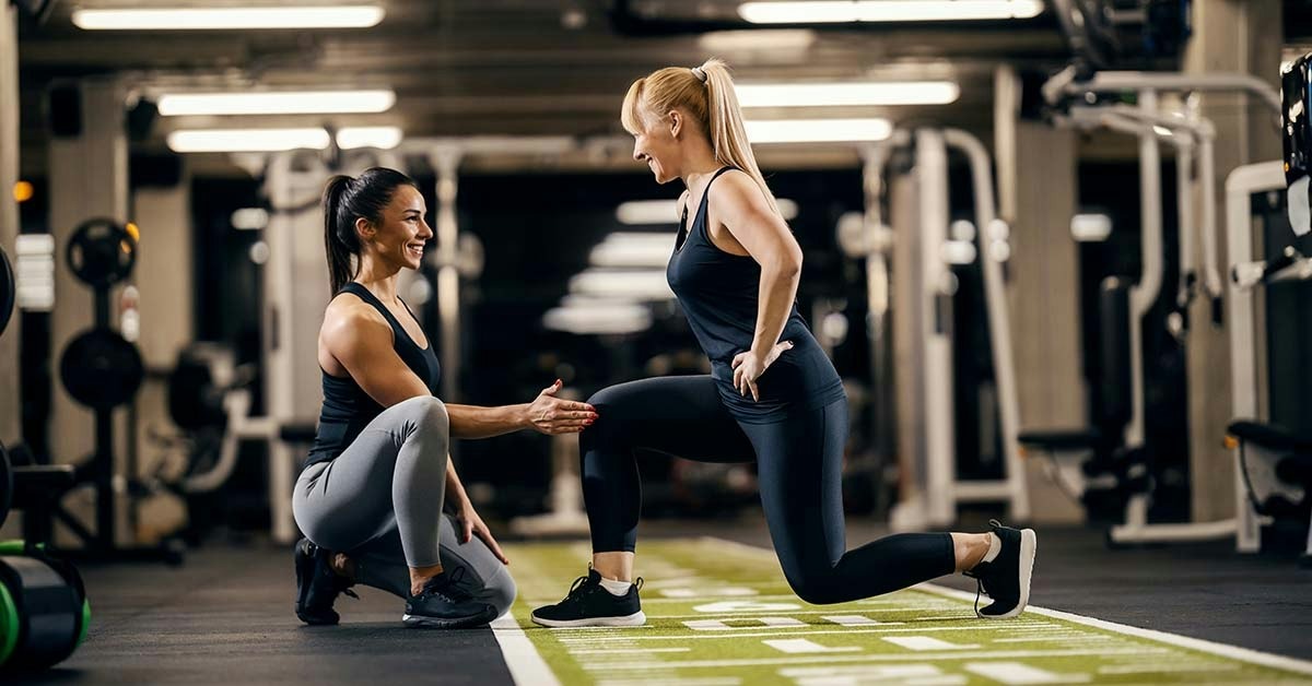 Imgi 169 1700105680 personal trainer is helping client to do exercises in a gym