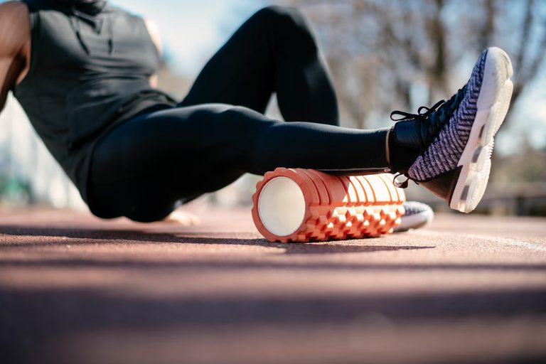 Imgi 169 young man stretching himself on a foam roller royalty free image