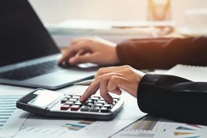 Imgi 328 business accounting finance concept accountant using calculator for calculate with laptop working in office free photo