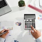 Imgi 348 businesswoman working on desk using calculator and laptop analyzing finance accounting in office free photo