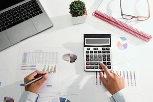 Imgi 348 businesswoman working on desk using calculator and laptop analyzing finance accounting in office free photo