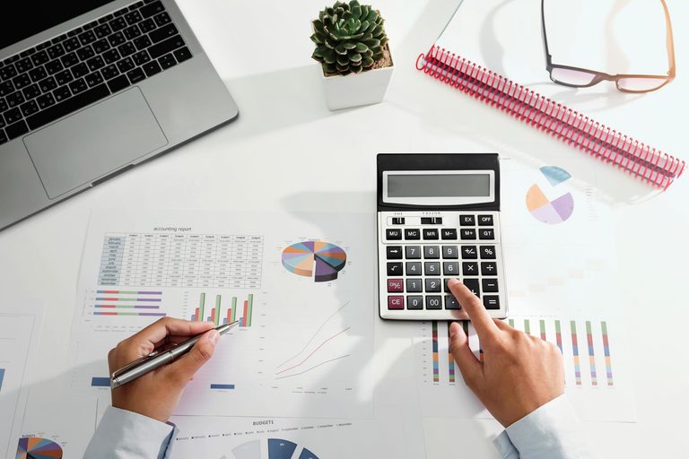 Imgi 348 businesswoman working on desk using calculator and laptop analyzing finance accounting in office free photo
