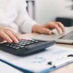 Imgi 354 businessperson using calculator laptop financial report office desk concept accounting analysis budget planning