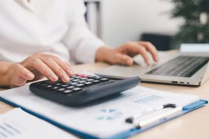Imgi 354 businessperson using calculator laptop financial report office desk concept accounting analysis budget planning