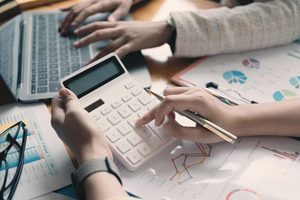 Imgi 402 close up businessman and partner using calculator and laptop for calaulating finance tax accounting statistics and analytic research concept fr