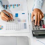 Imgi 409 woman accountant use calculator and computer with holding pen on desk in office finance and accounting concept free photo