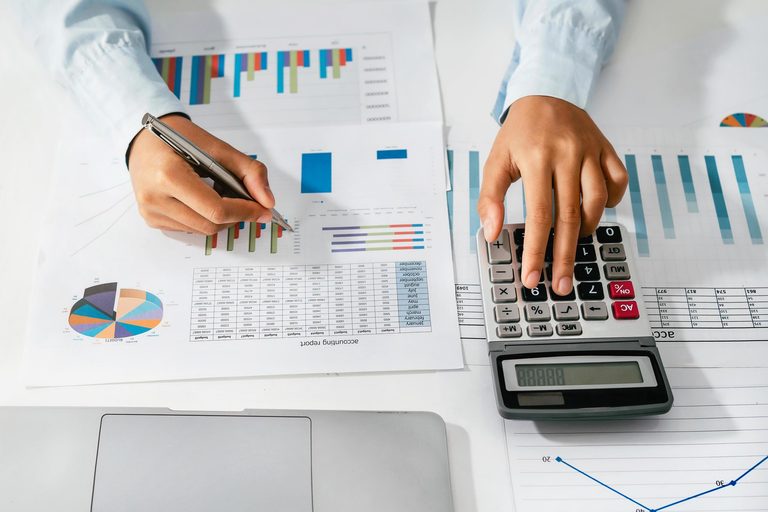 Imgi 409 woman accountant use calculator and computer with holding pen on desk in office finance and accounting concept free photo