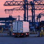 Logistics scene with cranes and a truck at Rotterdam port during sunset. Efficient cargo transportation hub.