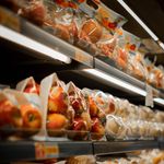 Packaged fresh apples displayed on a supermarket shelf with bright lighting.
