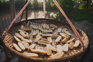 Slices of bananas sun-drying on a bamboo tray create a rustic, traditional ambiance.